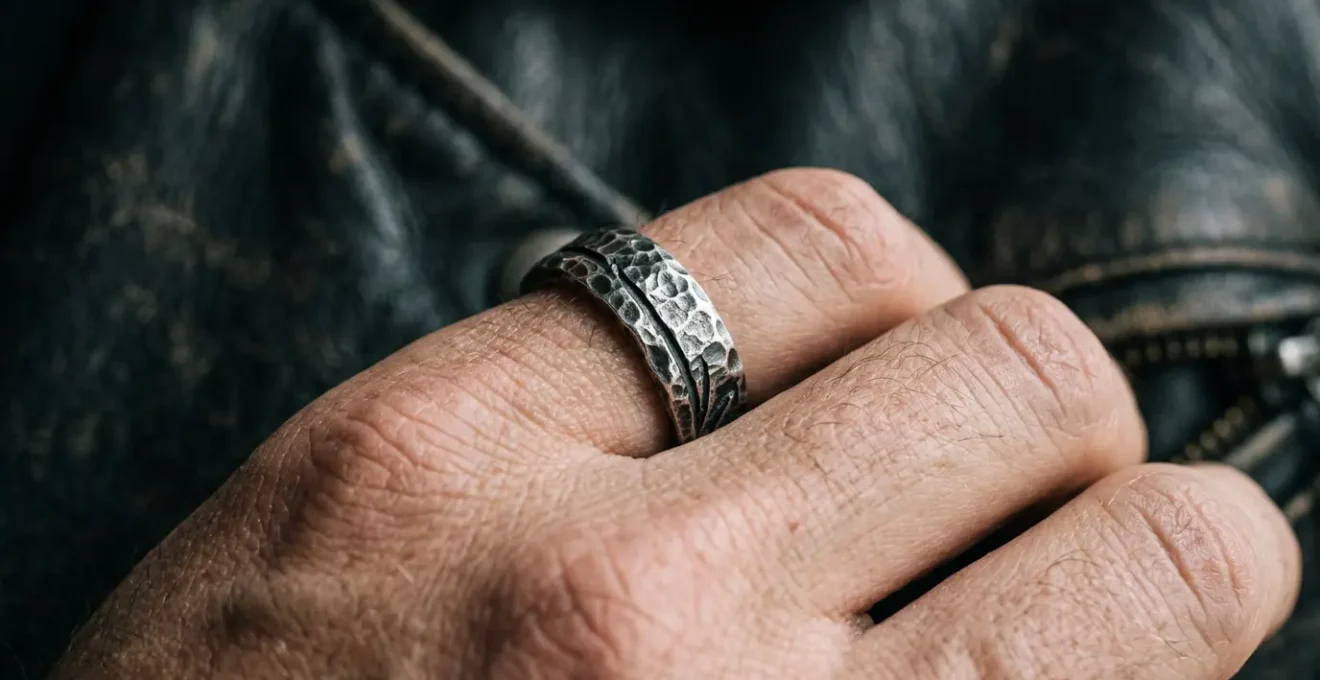 Mano masculina con anillo de plata oxidada mostrando textura martillada y relieves profundos